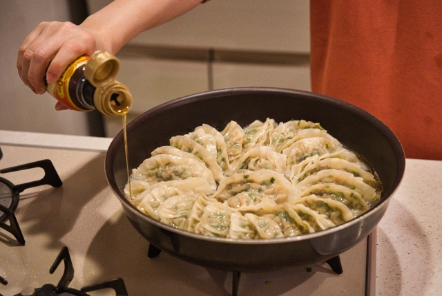 餃子にごま油をかけている写真